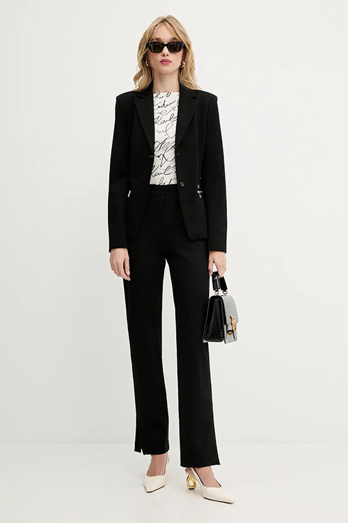 femeie imbracata cu sacou si pantaloni eleganti de culoare negru - tinute pentru interviu clasice 